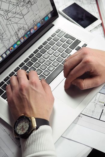 Blueprints, entrepreneur, hands — Bill Hutchinson: Transforming Challenges into Opportunities in the Dallas Real Estate Marke